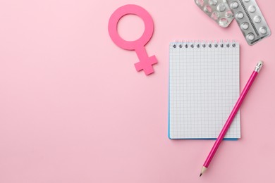 Photo of Flat lay composition with female gender sign and pills on pink background, space for text. Women's Health concept