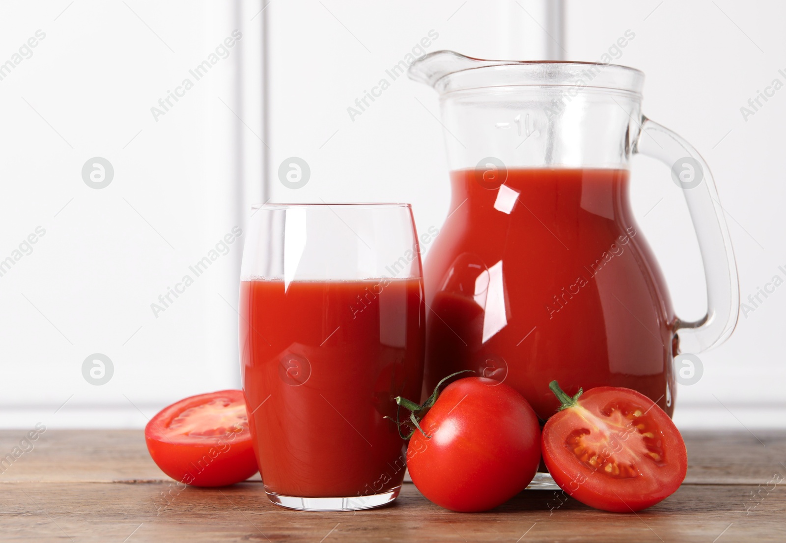 Photo of Tasty tomato juice and fresh vegetables on wooden table