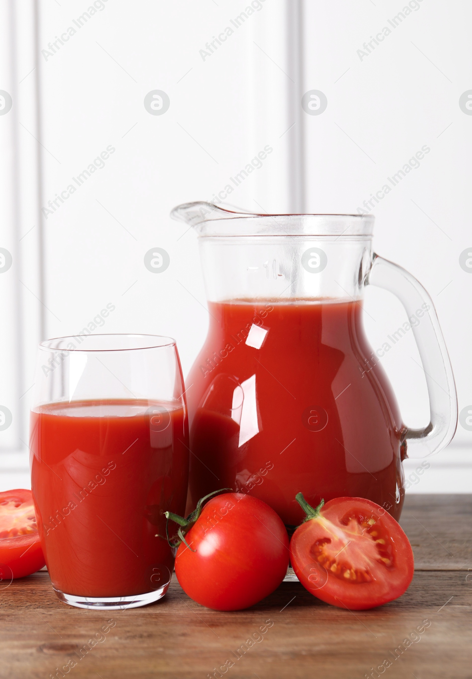 Photo of Tasty tomato juice and fresh vegetables on wooden table