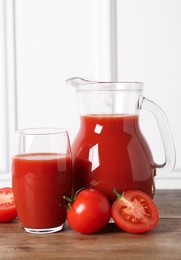 Photo of Tasty tomato juice and fresh vegetables on wooden table