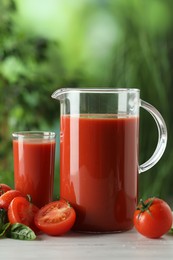 Tasty tomato juice, basil and fresh vegetables on white table outdoors