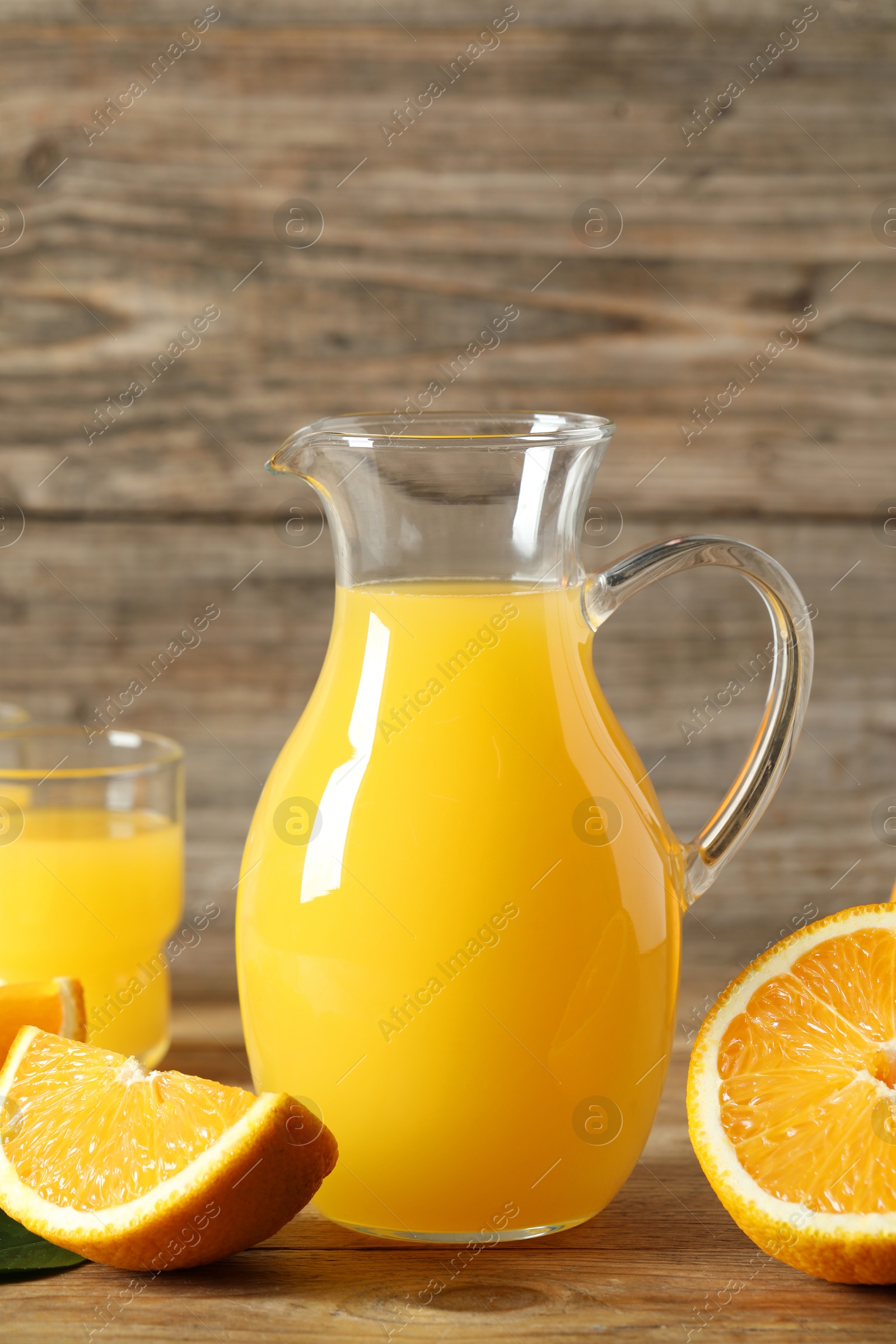 Photo of Tasty orange juice and fresh fruits on wooden table