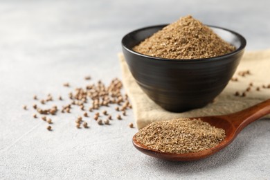 Photo of Coriander powder in spoon, bowl and seeds on light grey table. Space for text