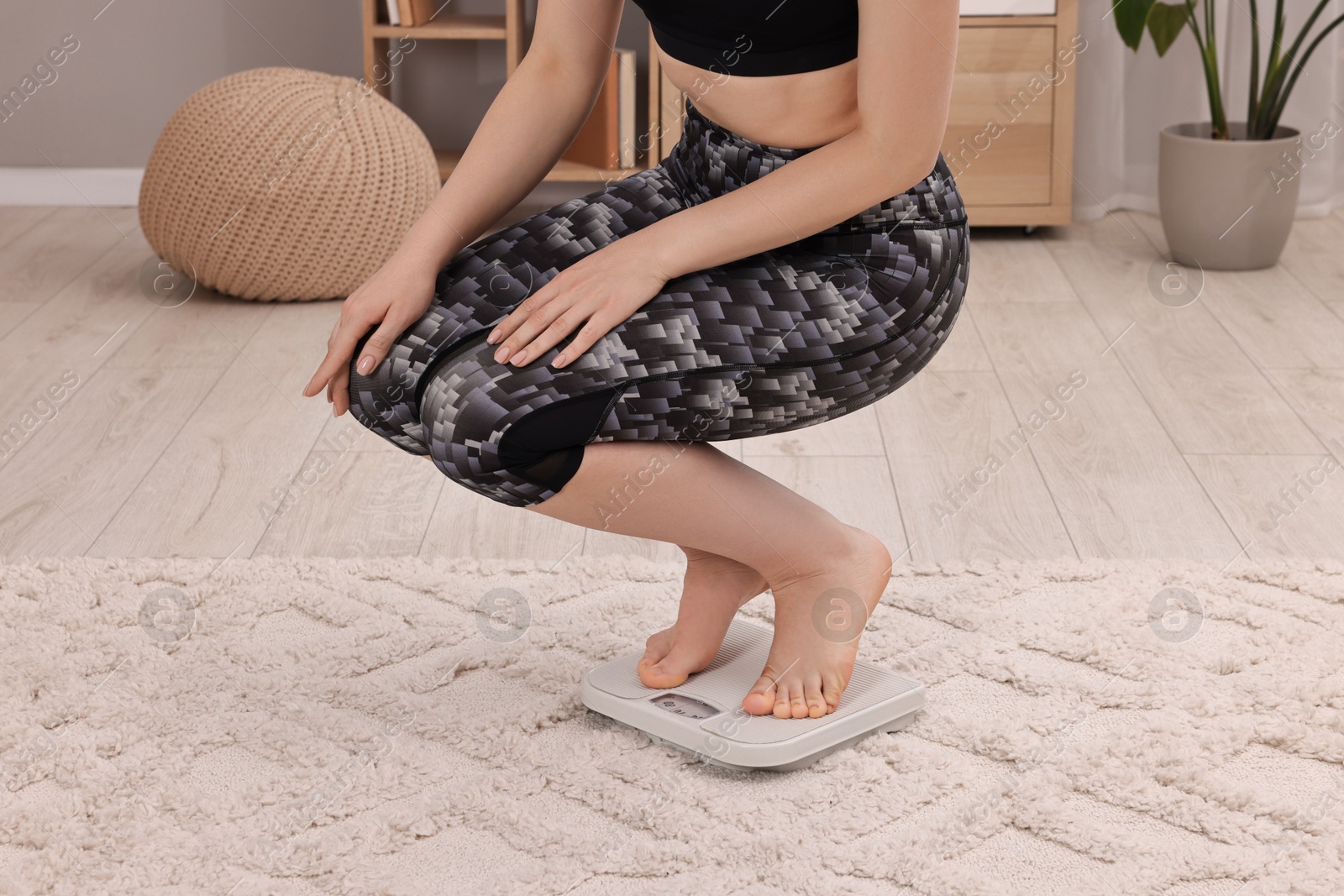 Photo of Woman on floor scale at home, closeup