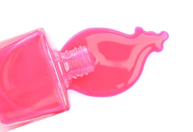 Overturned bottle of pink nail polish isolated on white, top view