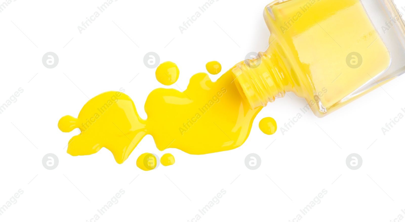 Photo of Overturned bottle of yellow nail polish isolated on white, top view