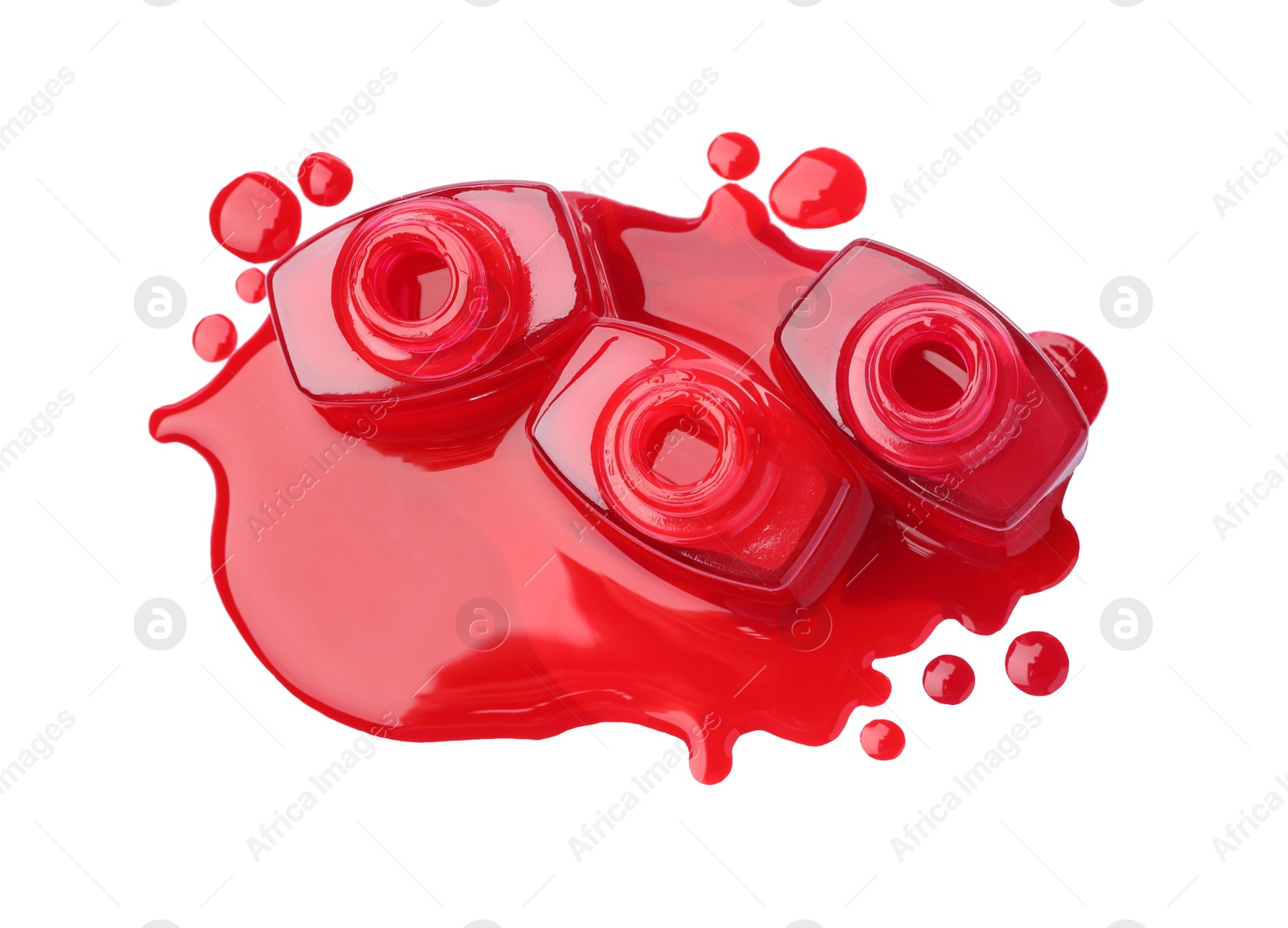 Photo of Puddle of red nail polish and bottles isolated on white, top view