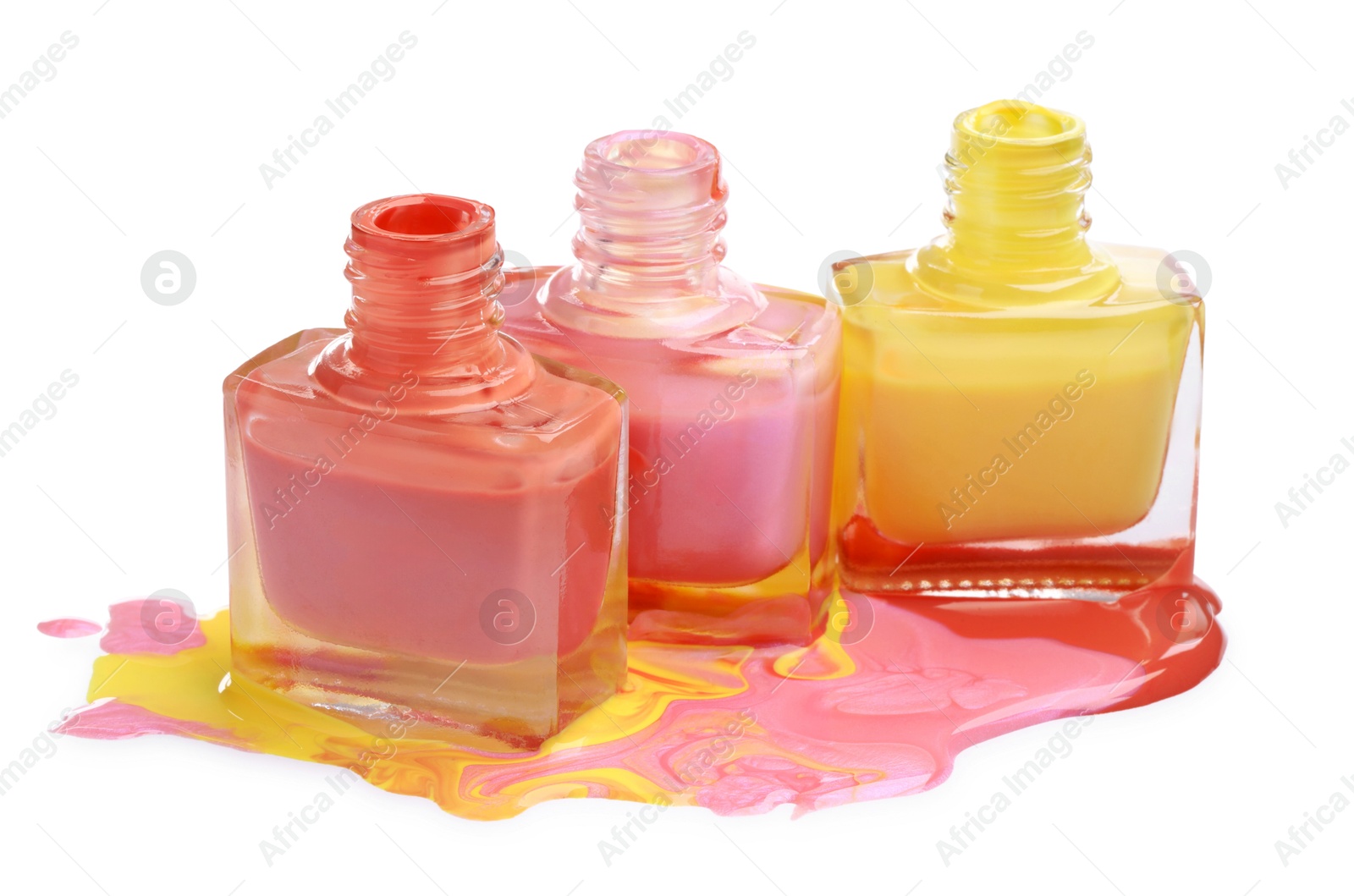 Photo of Puddle of different bright nail polishes and bottles isolated on white