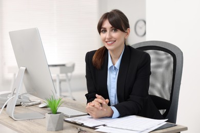 Photo of Portrait of smiling secretary at table in office