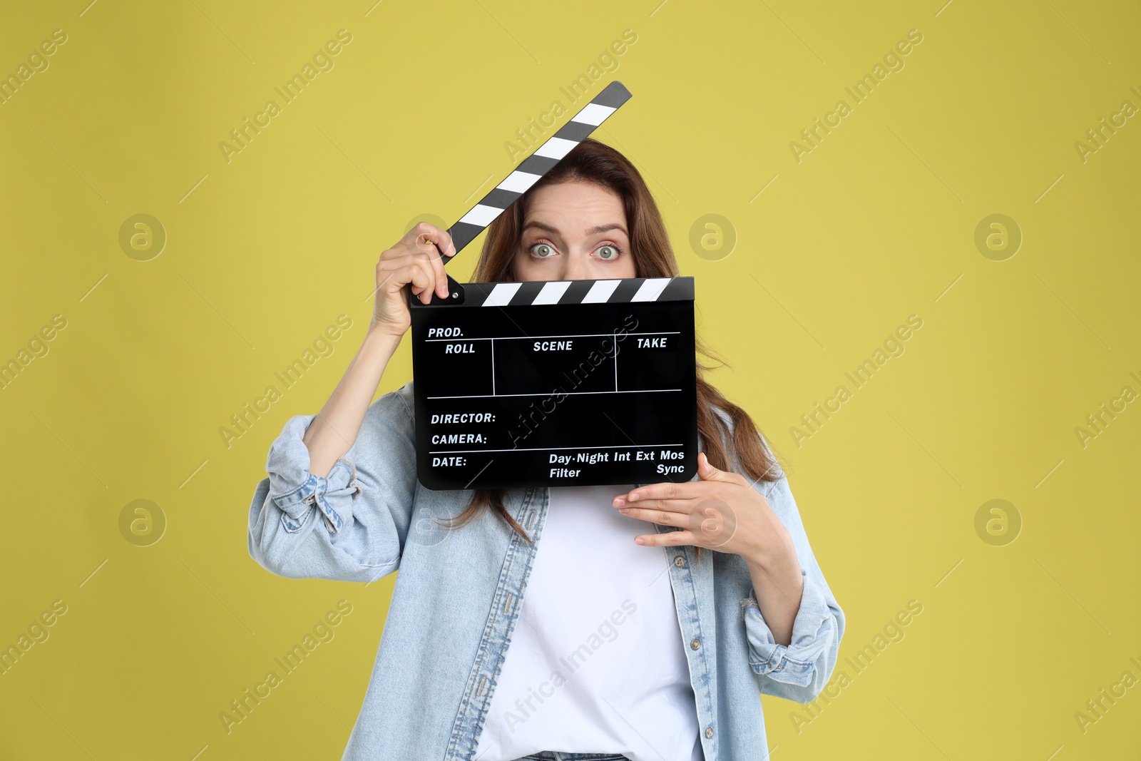 Photo of Making movie. Woman with clapperboard on yellow background