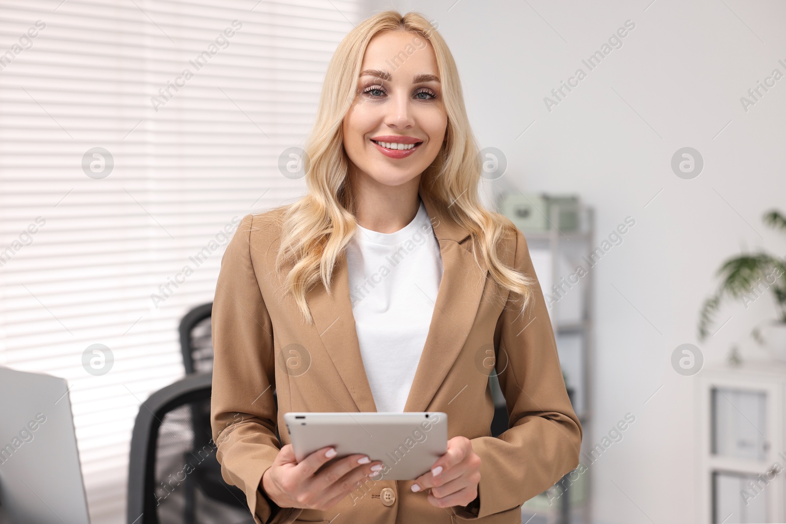 Photo of Portrait of happy secretary with tablet in office