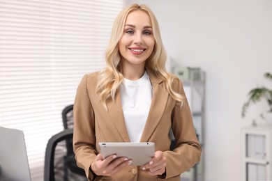 Portrait of happy secretary with tablet in office