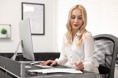 Photo of Secretary working with document at table in office