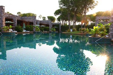 Outdoor swimming pool with umbrellas and sunbeds at resort