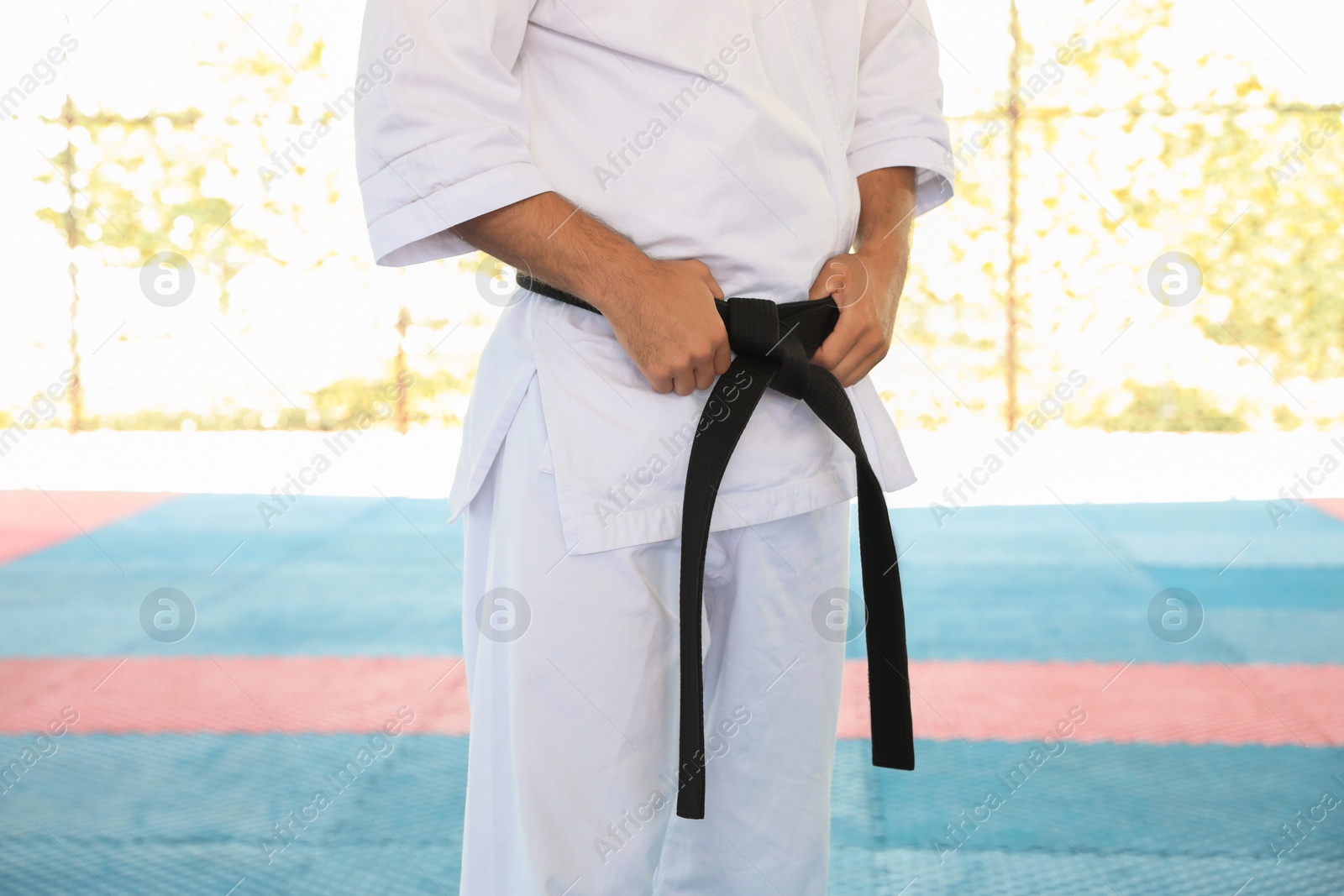 Photo of Karate coach wearing kimono and black belt at outdoor gym, closeup