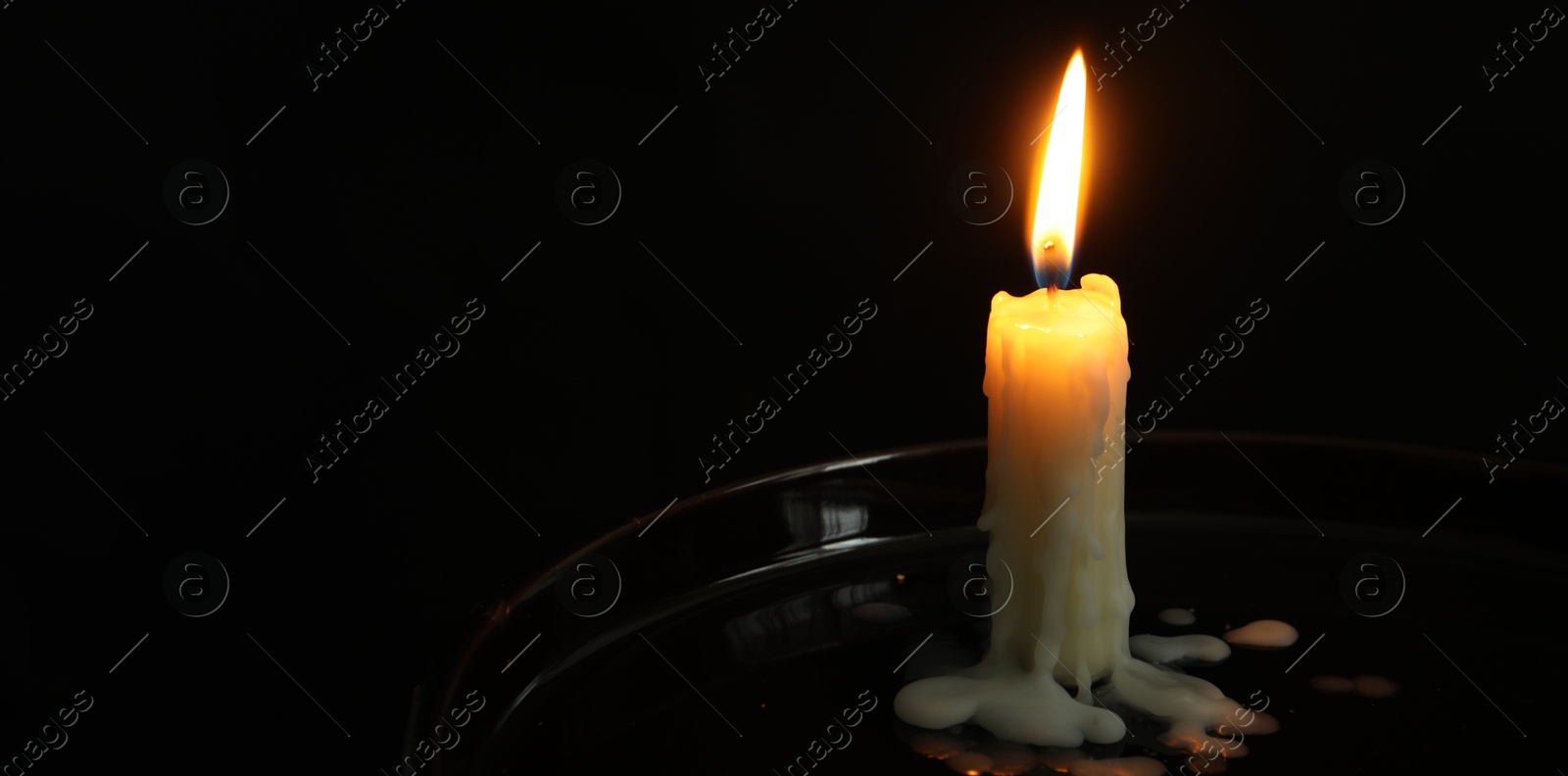 Photo of One burning church candle on black background, space for text