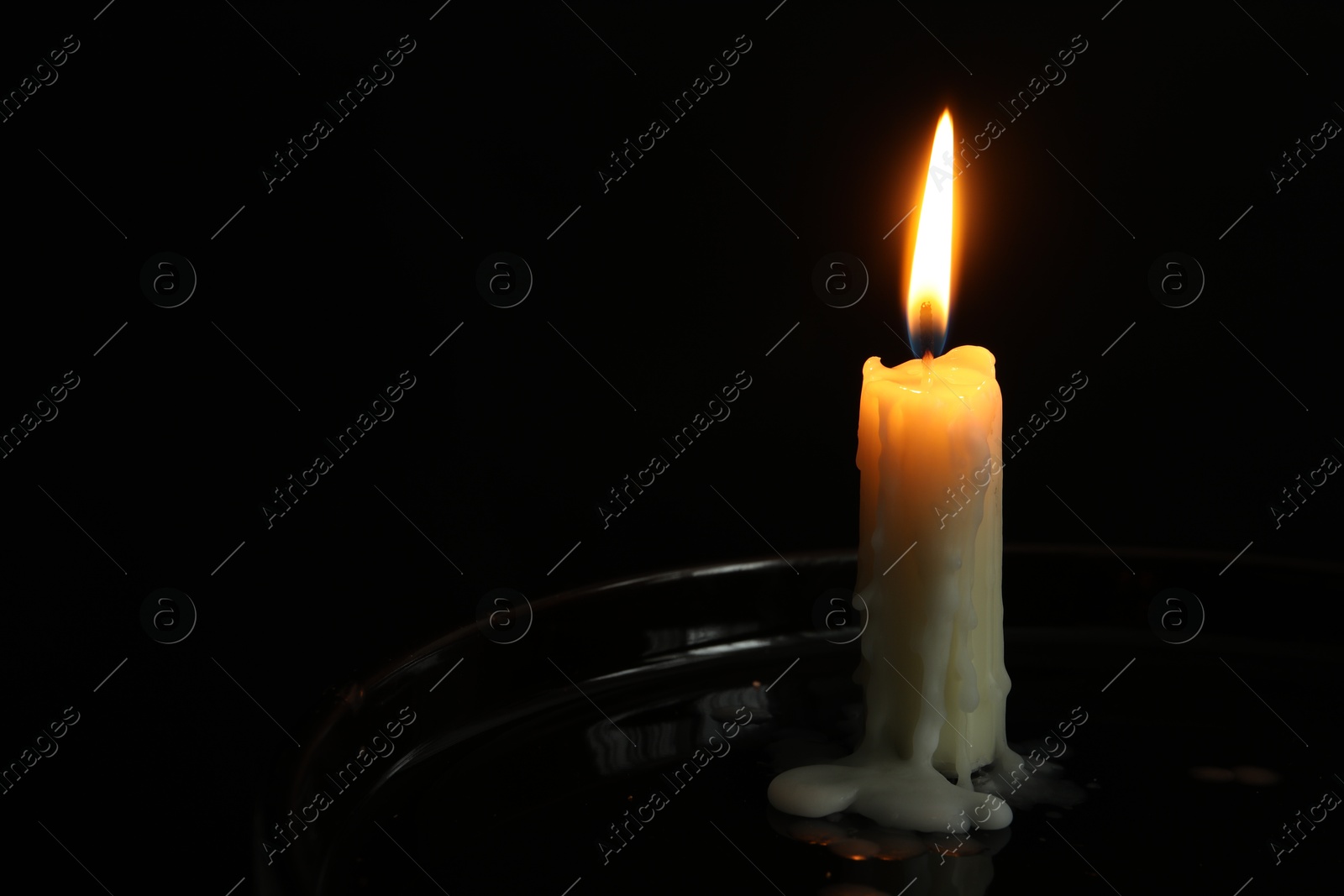 Photo of One burning church candle on black background, space for text