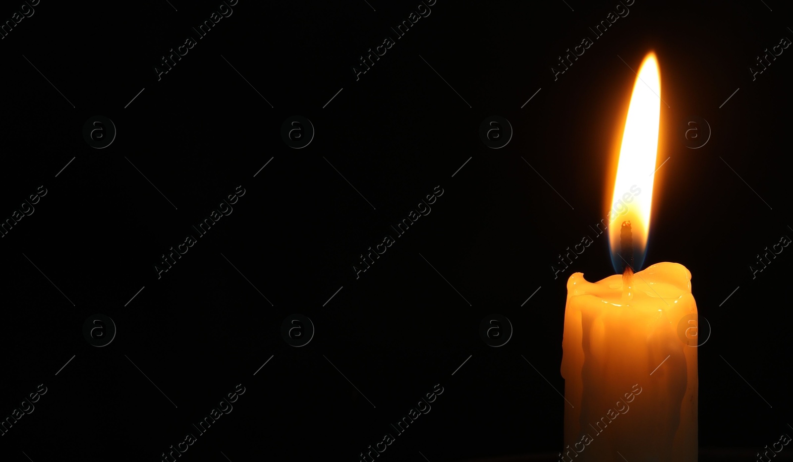 Photo of One burning church candle on black background, closeup. Space for text