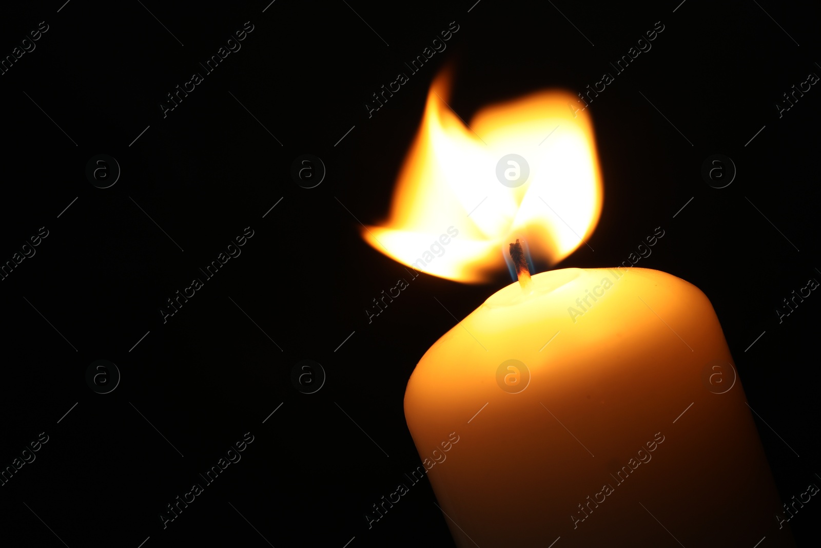 Photo of One burning church candle on black background, closeup. Space for text