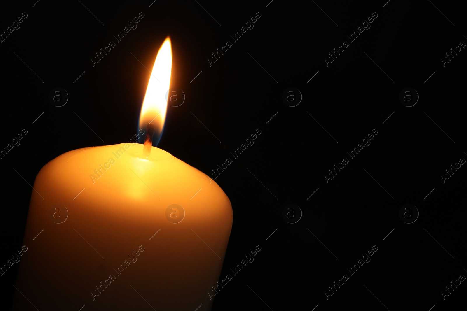 Photo of One burning church candle on black background, closeup. Space for text