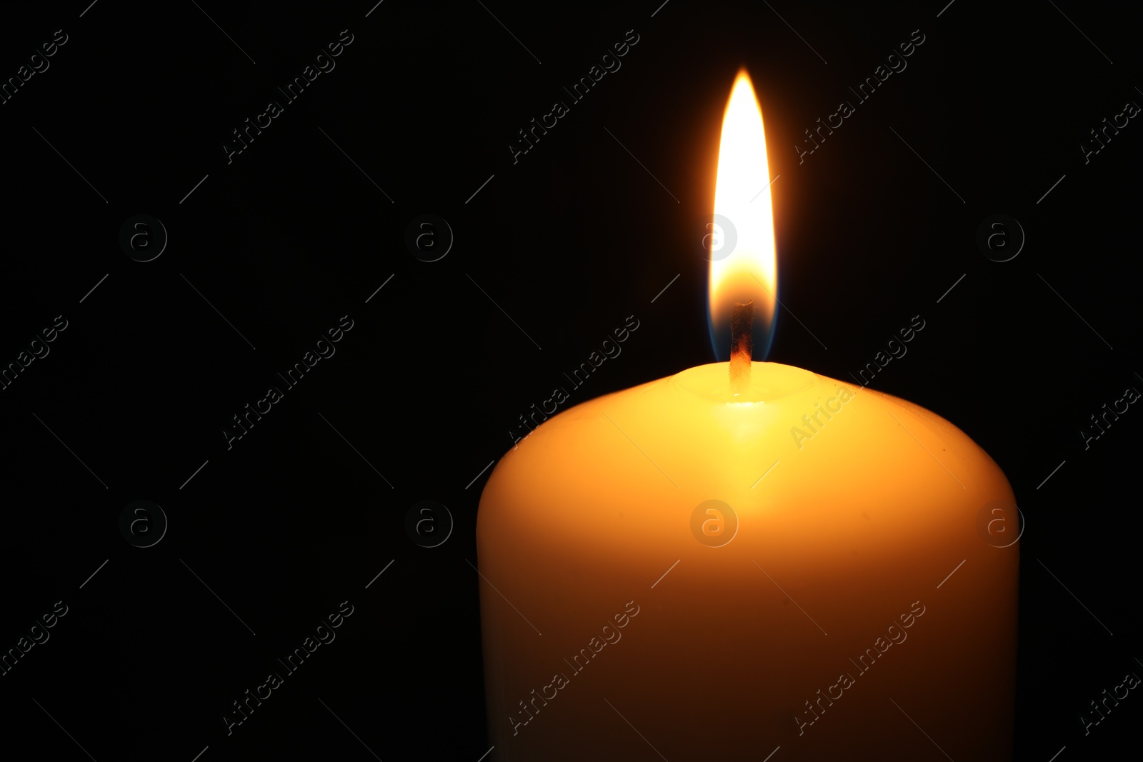 Photo of One burning church candle on black background, closeup. Space for text