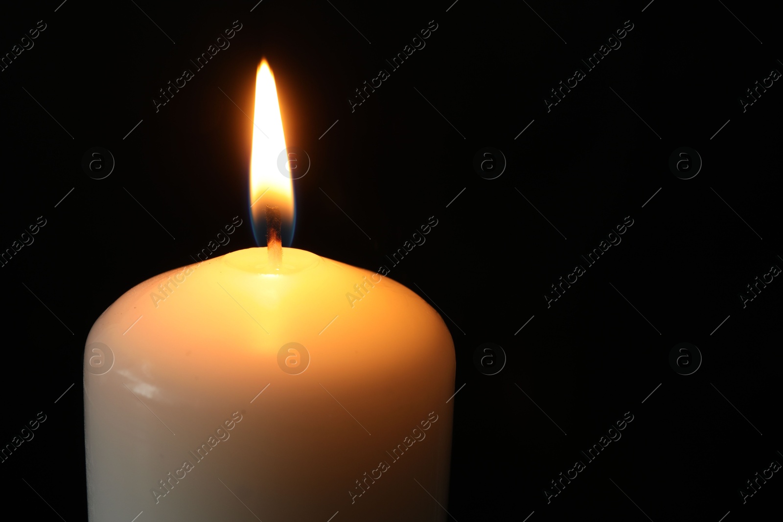 Photo of One burning church candle on black background, closeup. Space for text