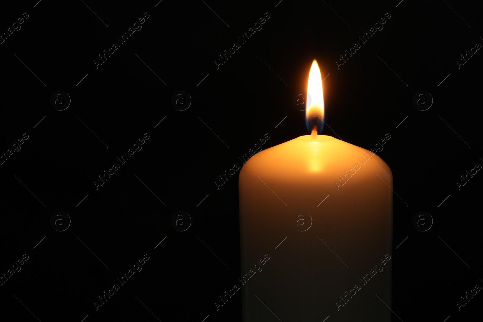 Photo of One burning church candle on black background, closeup. Space for text