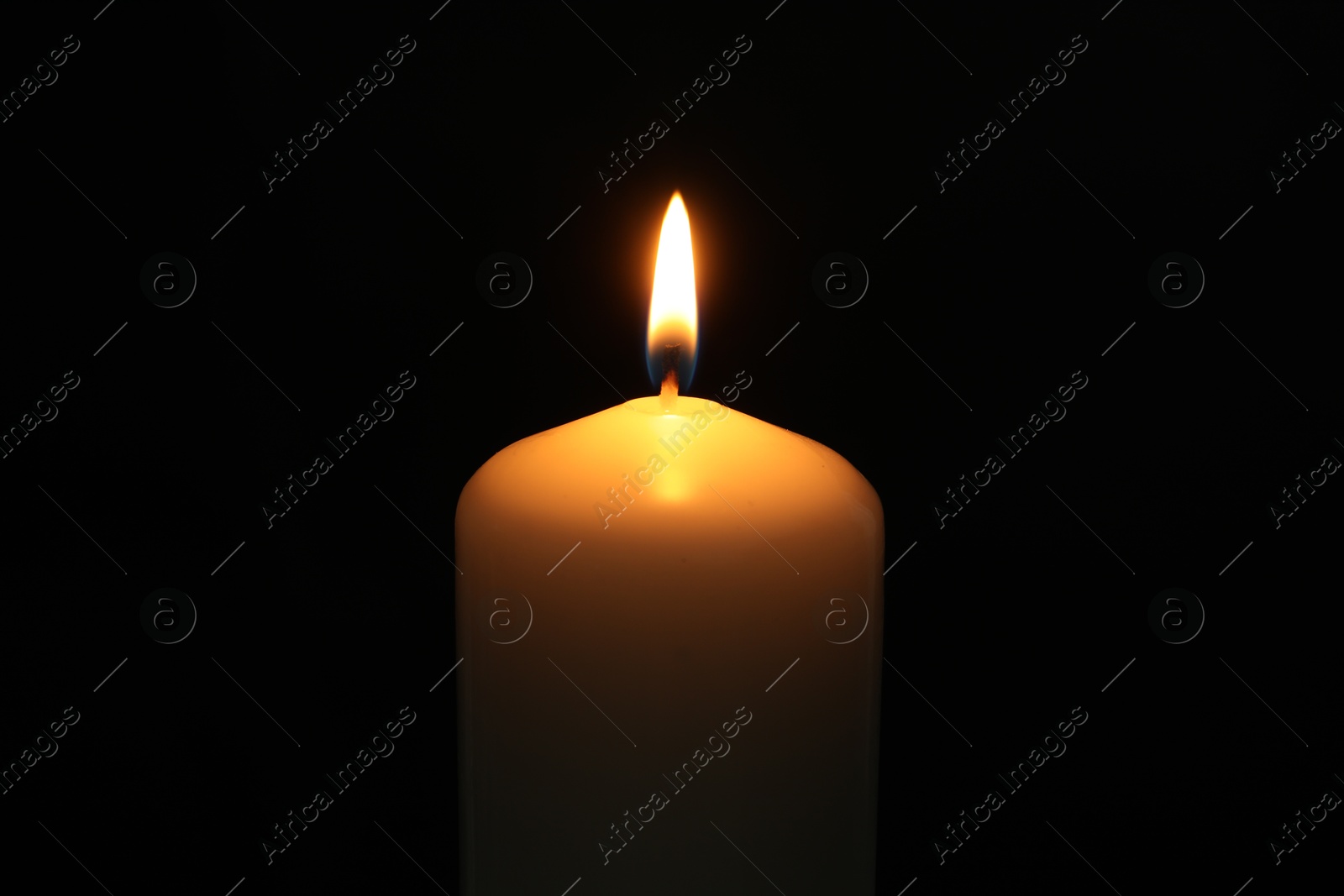 Photo of One burning church candle on black background, closeup