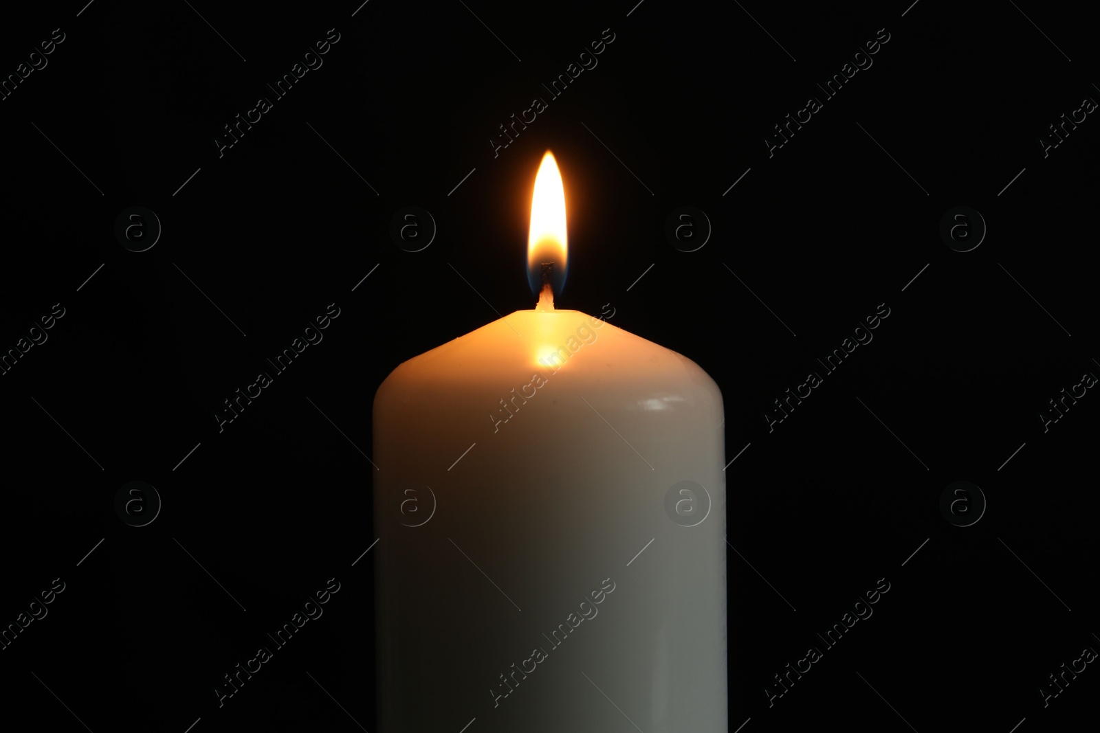 Photo of One burning church candle on black background, closeup