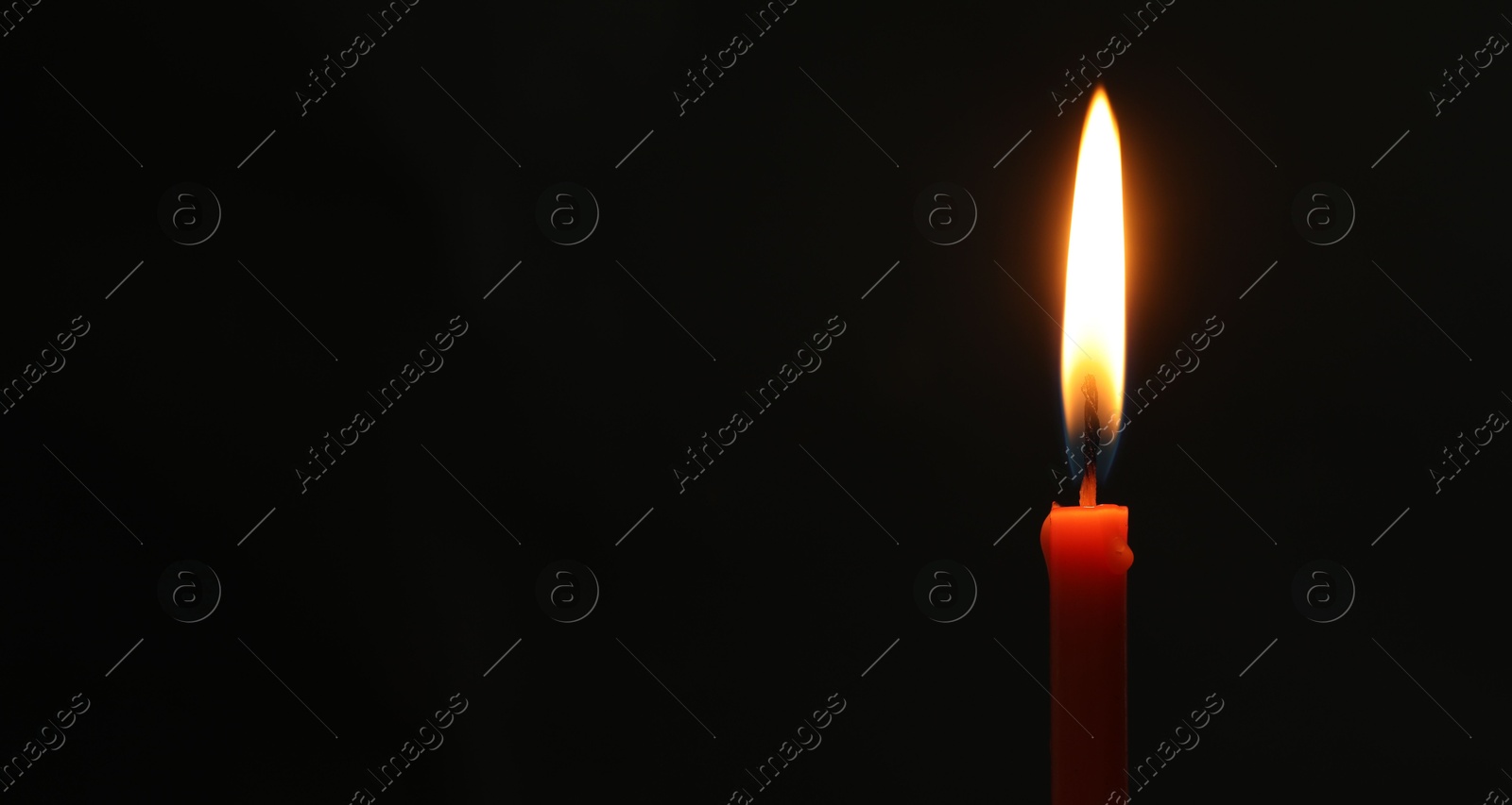 Photo of One burning church candle on black background, space for text