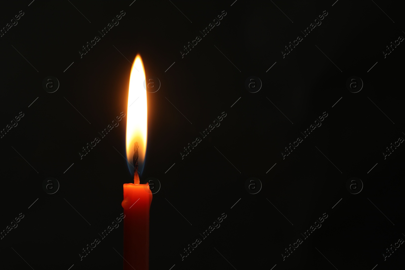 Photo of One burning church candle on black background, space for text