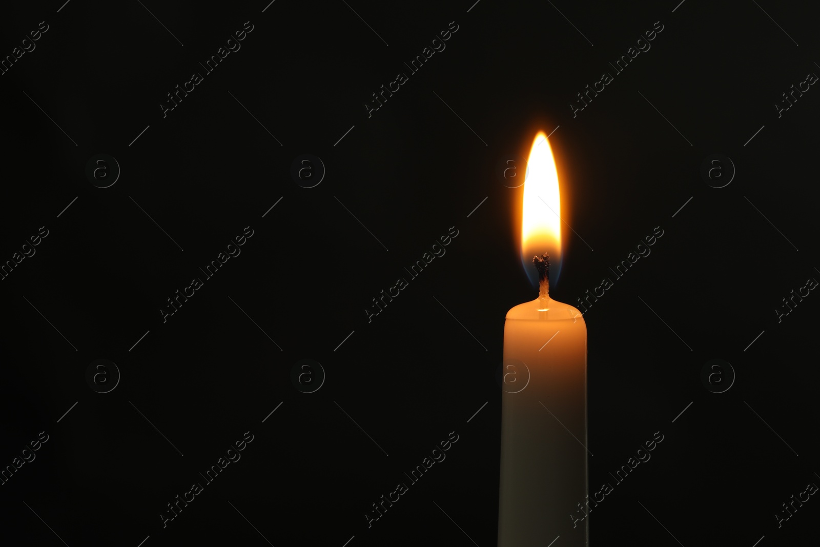 Photo of One burning church candle on black background, space for text