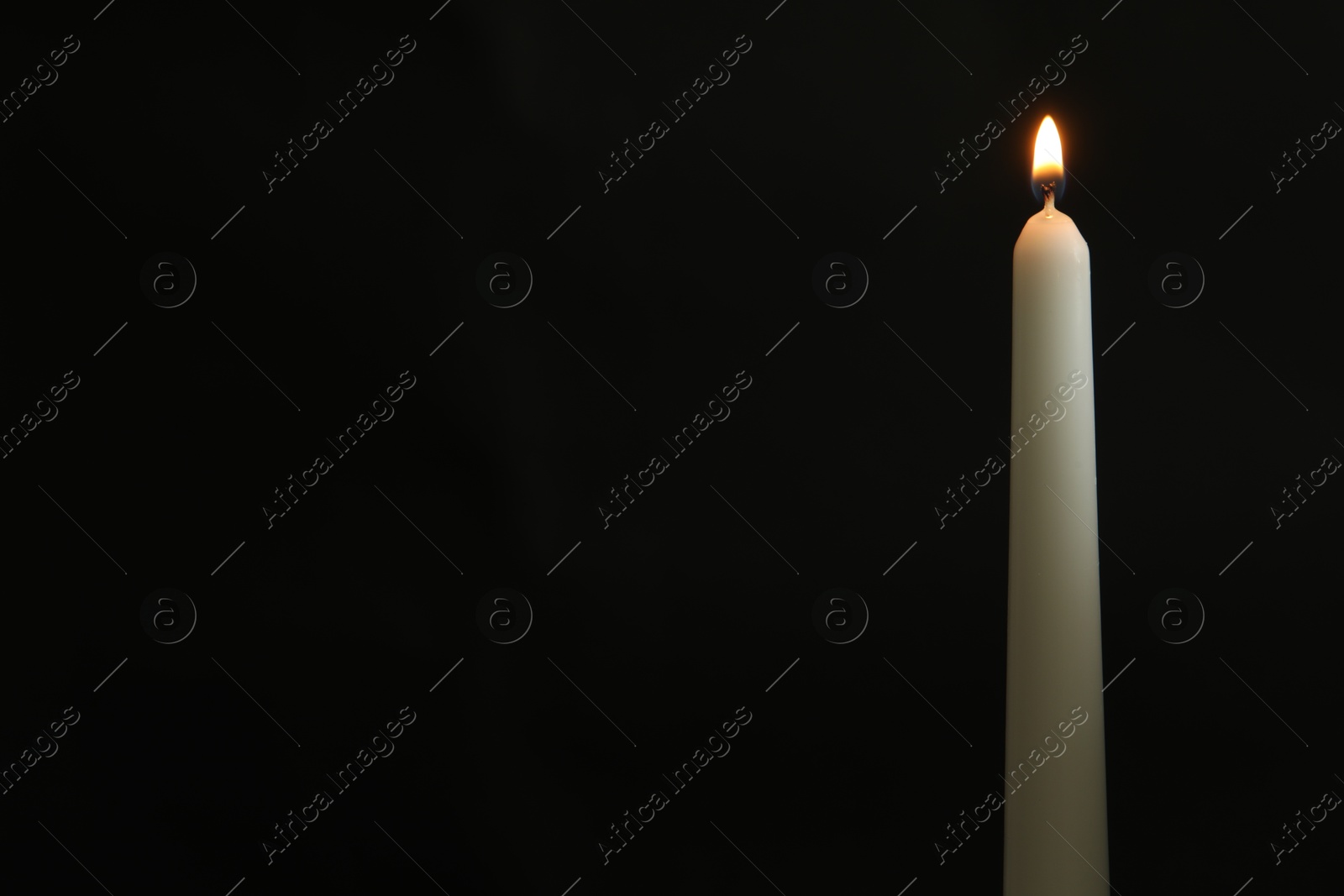 Photo of One burning church candle on black background, space for text