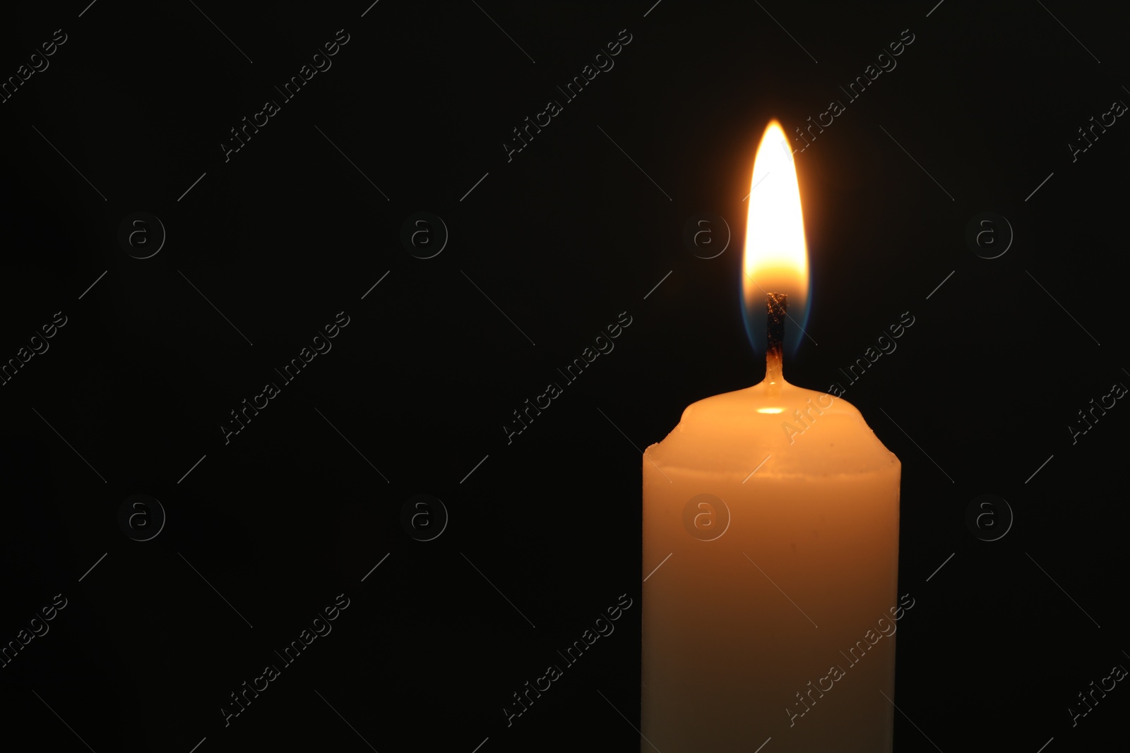 Photo of One burning church candle on black background, closeup. Space for text