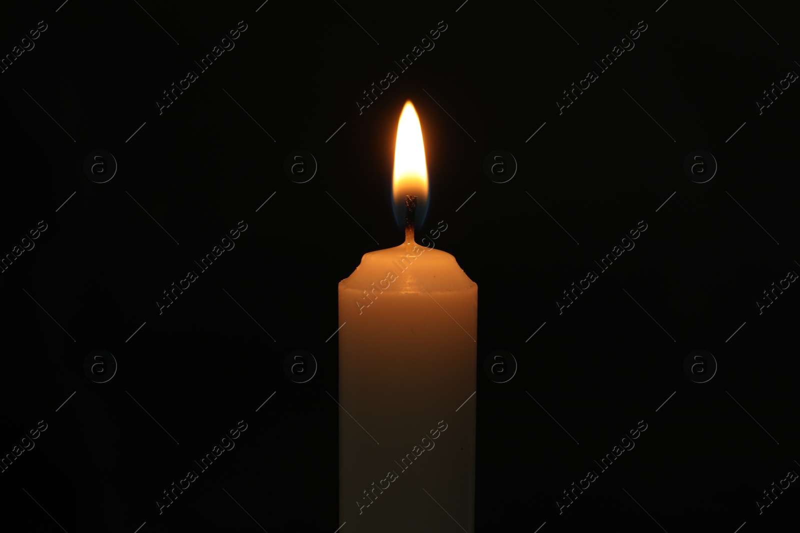 Photo of One burning church candle on black background, closeup