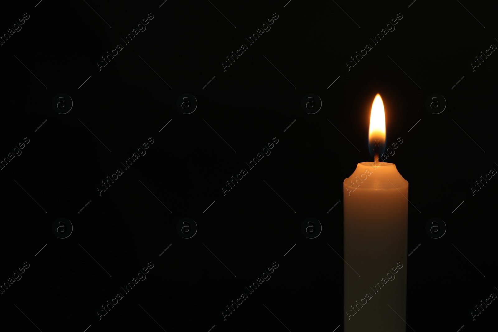 Photo of One burning church candle on black background, space for text