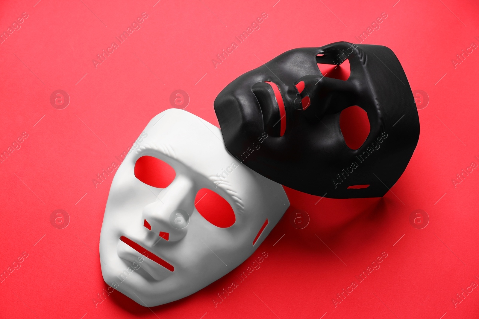 Photo of Theater arts. White and black masks on red background