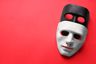 Photo of Theater arts. White and black masks on red background, top view. Space for text