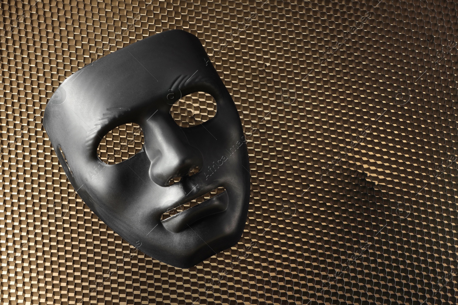 Photo of Theater arts. Black mask on honeycomb grid, top view. Space for text