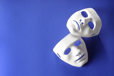 Theater arts. White masks on blue background, top view. Space for text
