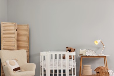 Newborn baby room interior with stylish furniture and comfortable crib