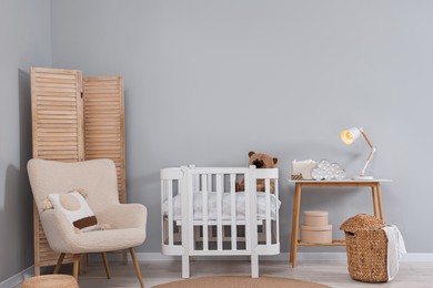 Photo of Newborn baby room interior with stylish furniture and comfortable crib