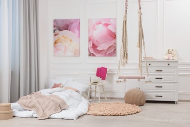 Photo of Cute child's room interior with swing and beautiful pictures of on wall