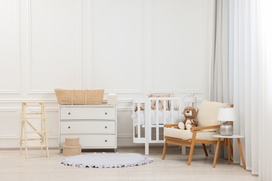 Photo of Newborn baby room interior with stylish furniture and comfortable crib