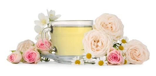 Aromatic herbal tea in glass cup and flowers isolated on white