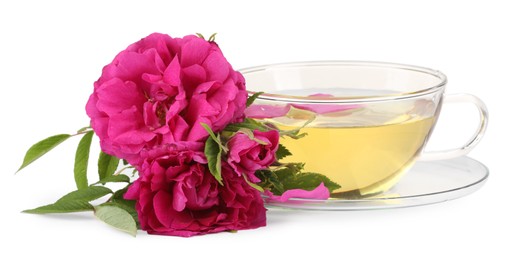 Photo of Aromatic herbal tea in glass cup, peonies and green leaves isolated on white