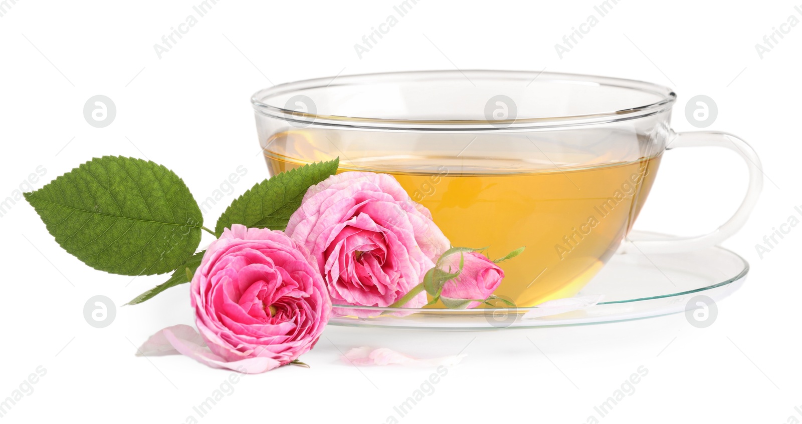 Photo of Aromatic herbal tea in glass cup, flowers and green leaves isolated on white