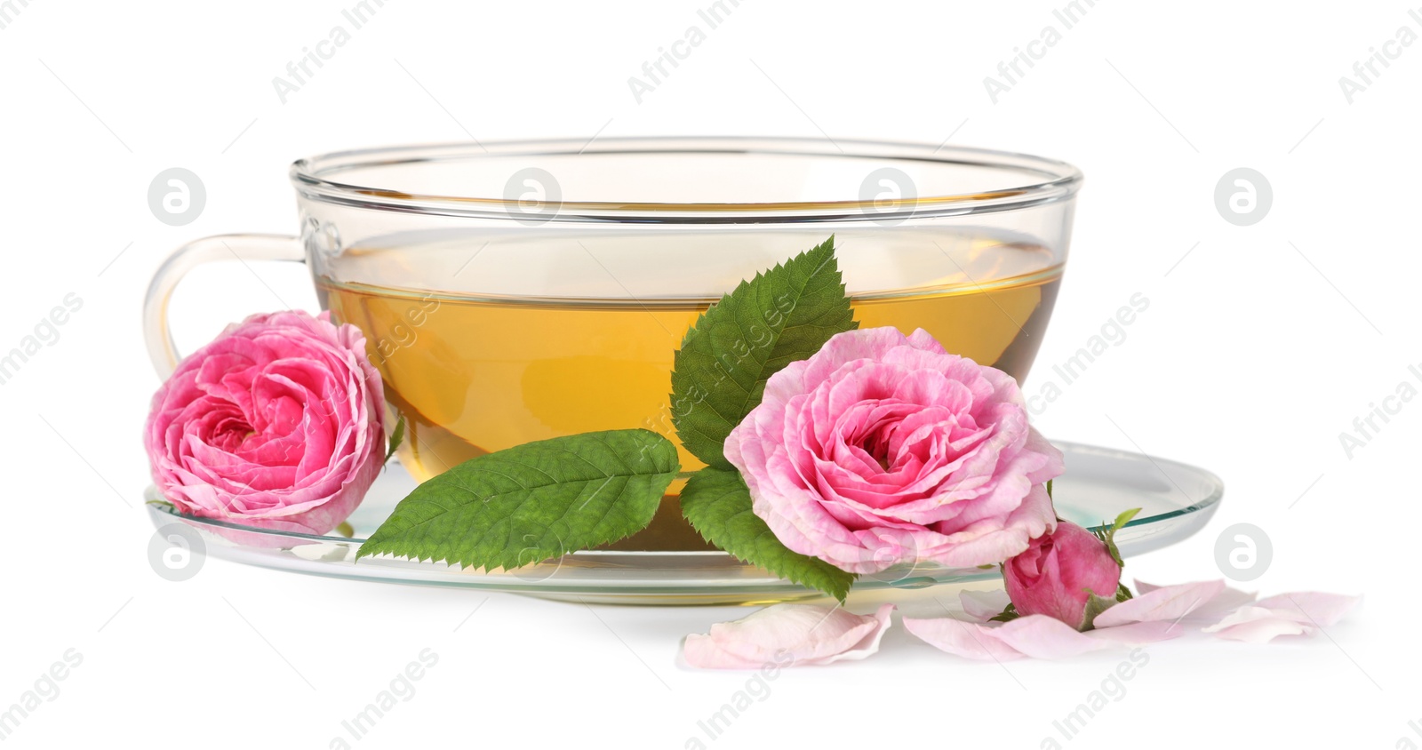 Photo of Aromatic herbal tea in glass cup, flowers and green leaves isolated on white