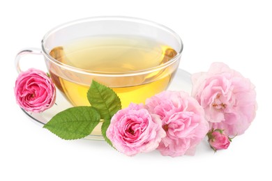 Photo of Aromatic herbal tea in glass cup, flowers and green leaves isolated on white