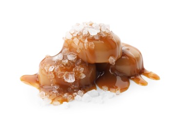 Photo of Yummy candies with caramel sauce and sea salt isolated on white